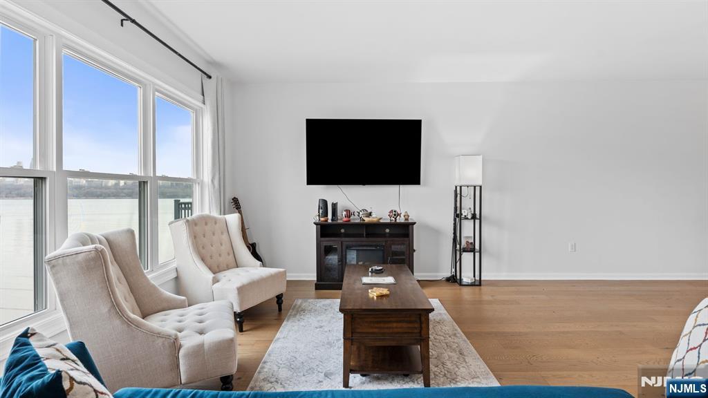 344 The Promenade, Unit 344 Edgewater, NJ 07020 - Photo 11 of 44 a living room with furniture a flat screen tv and a fireplace