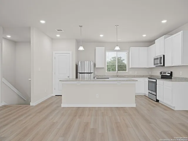 an empty room with windows and fan