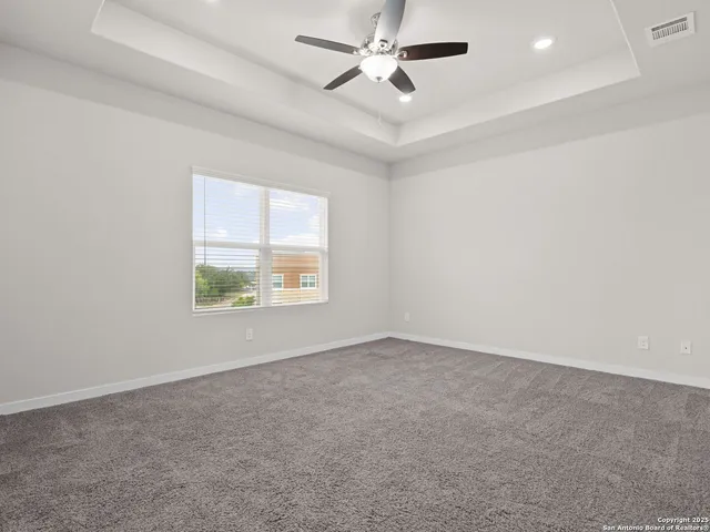 a view of an empty room with a chandelier fan
