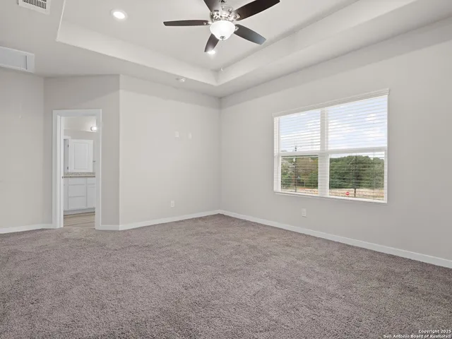a bathroom with a granite countertop bathtub a sink and a window
