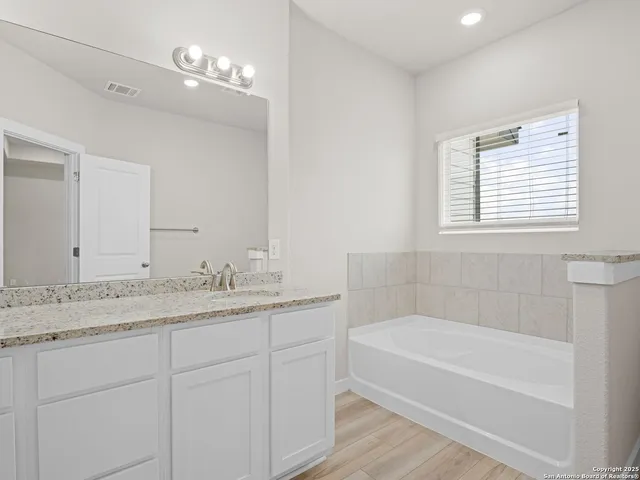 a bathroom with a granite countertop sink and a mirror