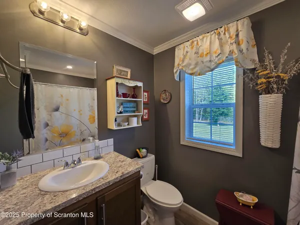 a bathroom with a granite countertop sink mirror vanity and toilet