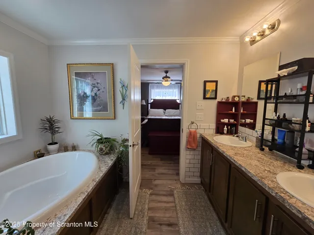 a bathroom with a granite countertop sink a mirror and a shower