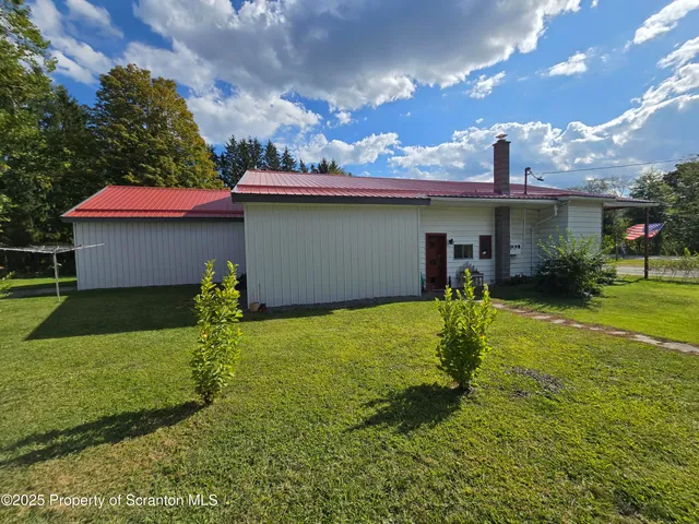 a backyard of a house with table and chairs