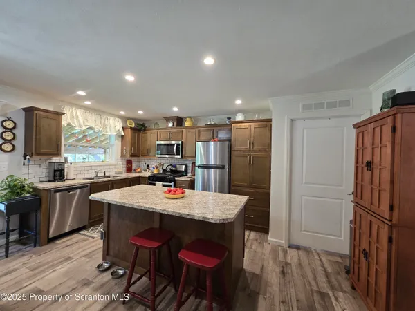 a kitchen with refrigerator and chairs