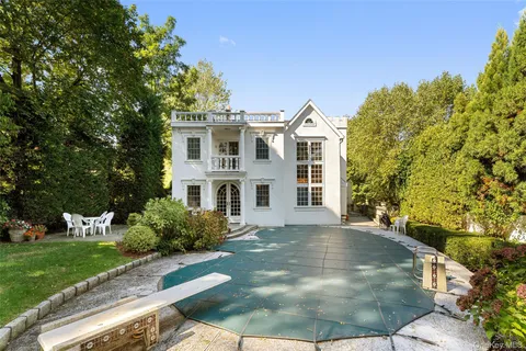a view of a white house with a yard and potted plants
