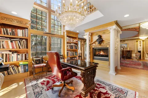 a living room with furniture a bookshelf and a chandelier