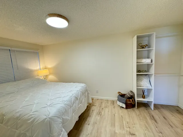 a bedroom with a bed and a wooden floor