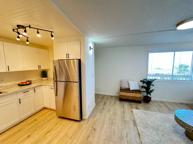 a kitchen with a refrigerator and a stove top oven