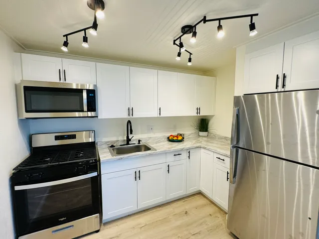 a kitchen with a sink stainless steel appliances and cabinets