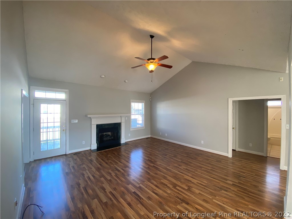 3532 Talus Road Fayetteville, NC 28306 - Photo 11 of 34 an empty room with wooden floor fireplace and windows