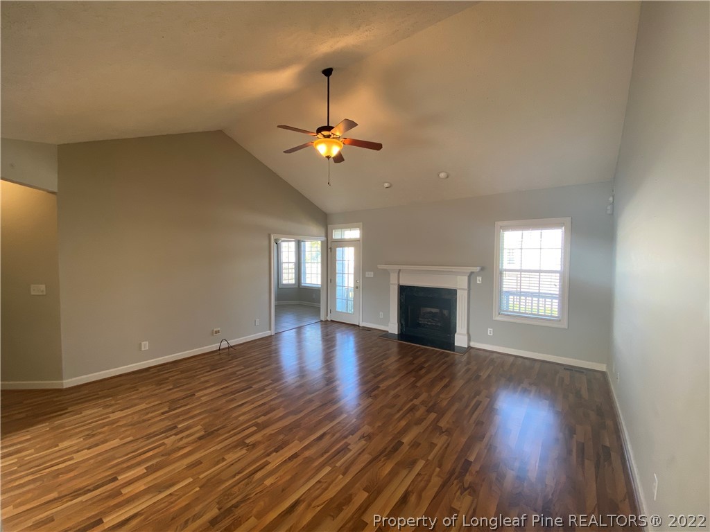 3532 Talus Road Fayetteville, NC 28306 - Photo 12 of 34 an empty room with wooden floor chandelier fan and windows