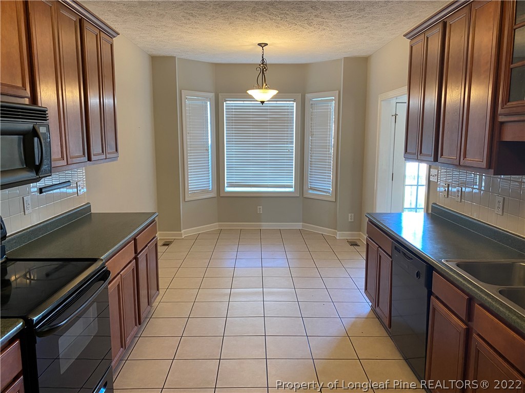 3532 Talus Road Fayetteville, NC 28306 - Photo 14 of 34 a kitchen with granite countertop stainless steel appliances a sink stove top oven and granite counter top