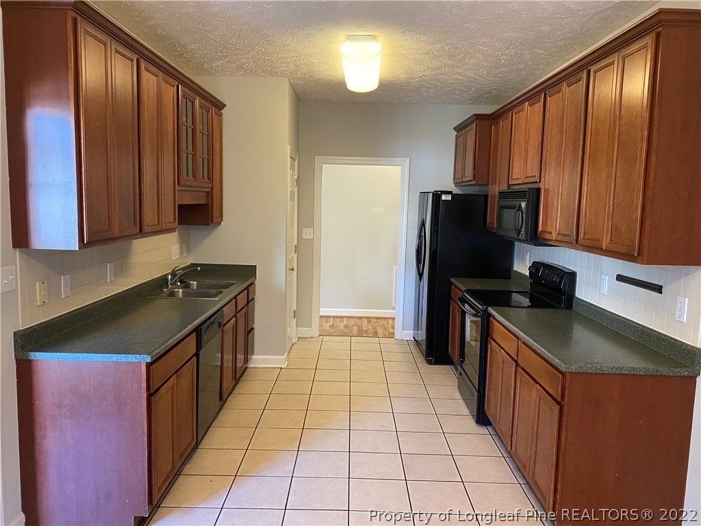 3532 Talus Road Fayetteville, NC 28306 - Photo 15 of 34 a kitchen with a refrigerator a stove top oven cabinets and a sink