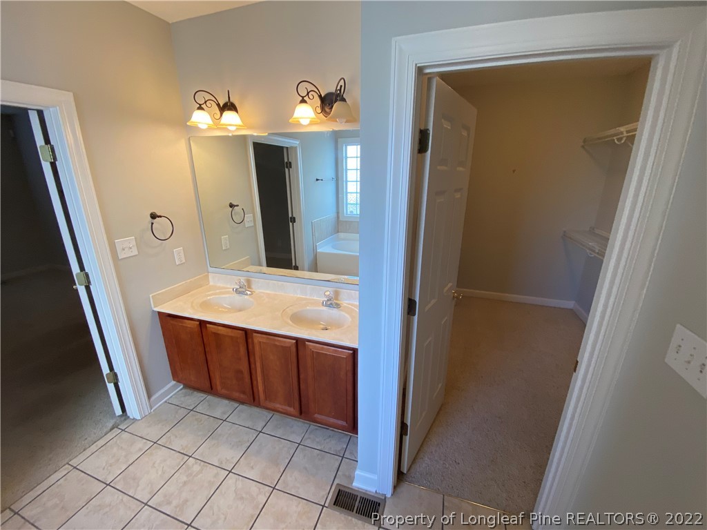 3532 Talus Road Fayetteville, NC 28306 - Photo 25 of 34 a bathroom with a sink a mirror and a vanity