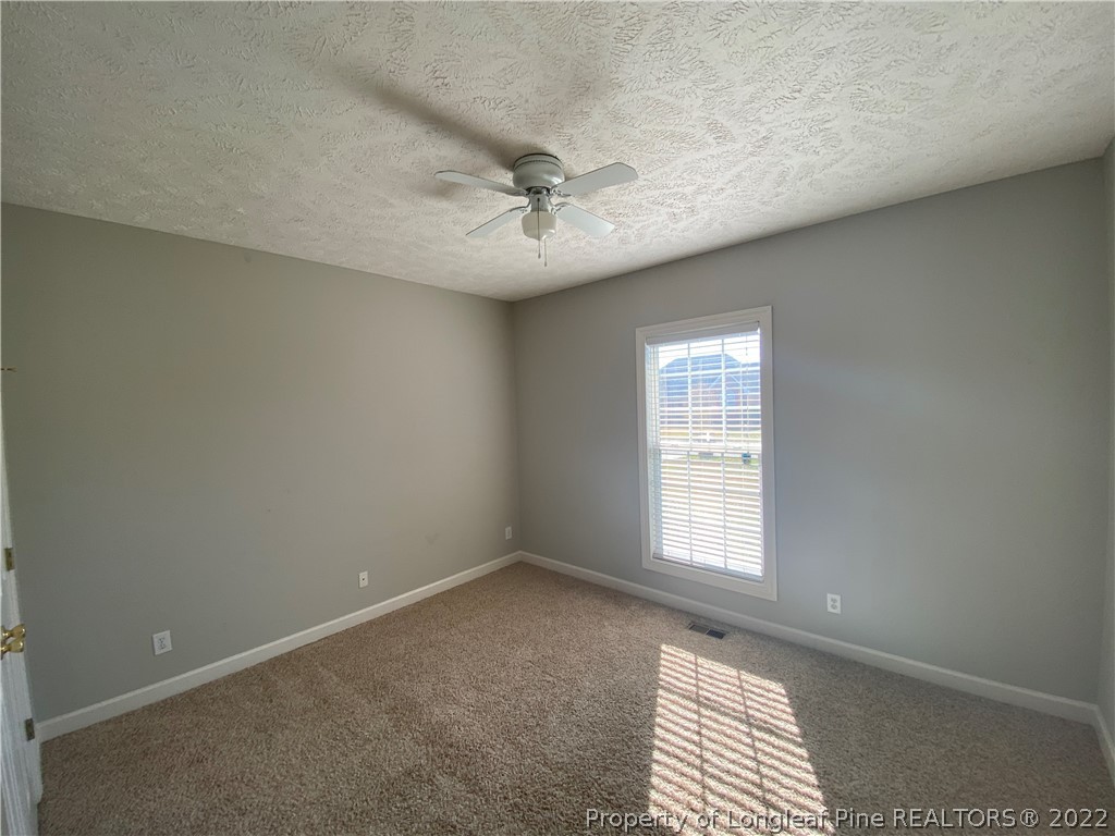 3532 Talus Road Fayetteville, NC 28306 - Photo 31 of 34 an empty room with windows and fan
