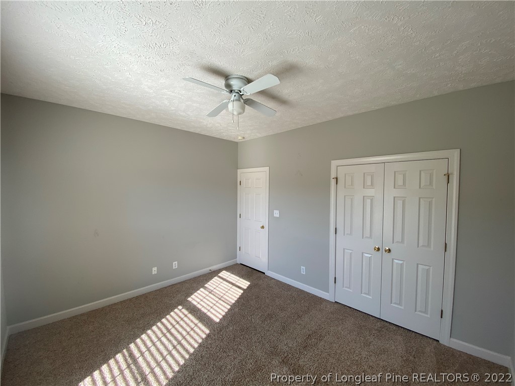 3532 Talus Road Fayetteville, NC 28306 - Photo 32 of 34 an empty room with a ceiling fan and carpet