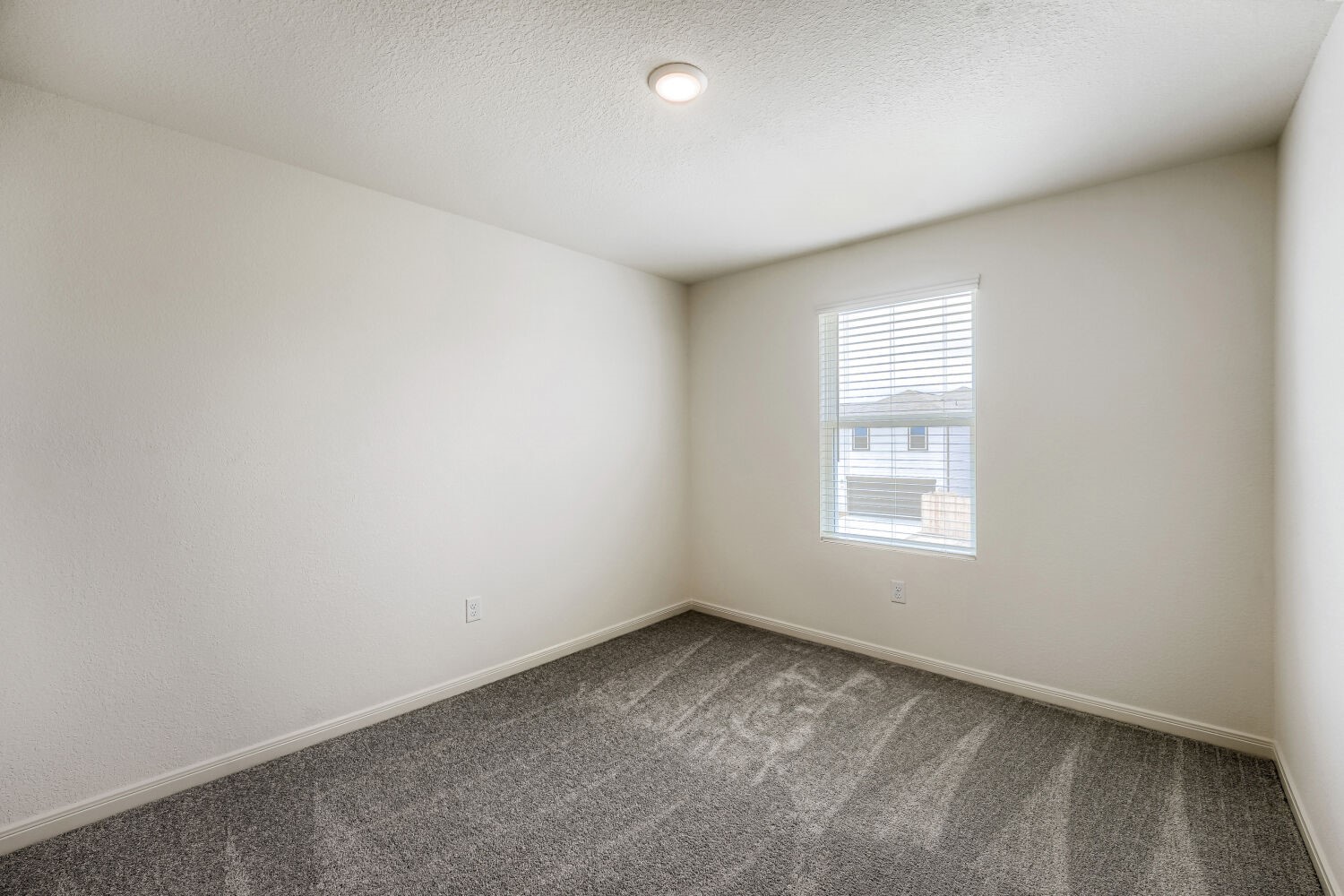 124 Mullen Way Taylor, TX 76574 - Photo 15 of 22 Room featuring a neutral color palette, grey textured carpeting, and a single window with blinds