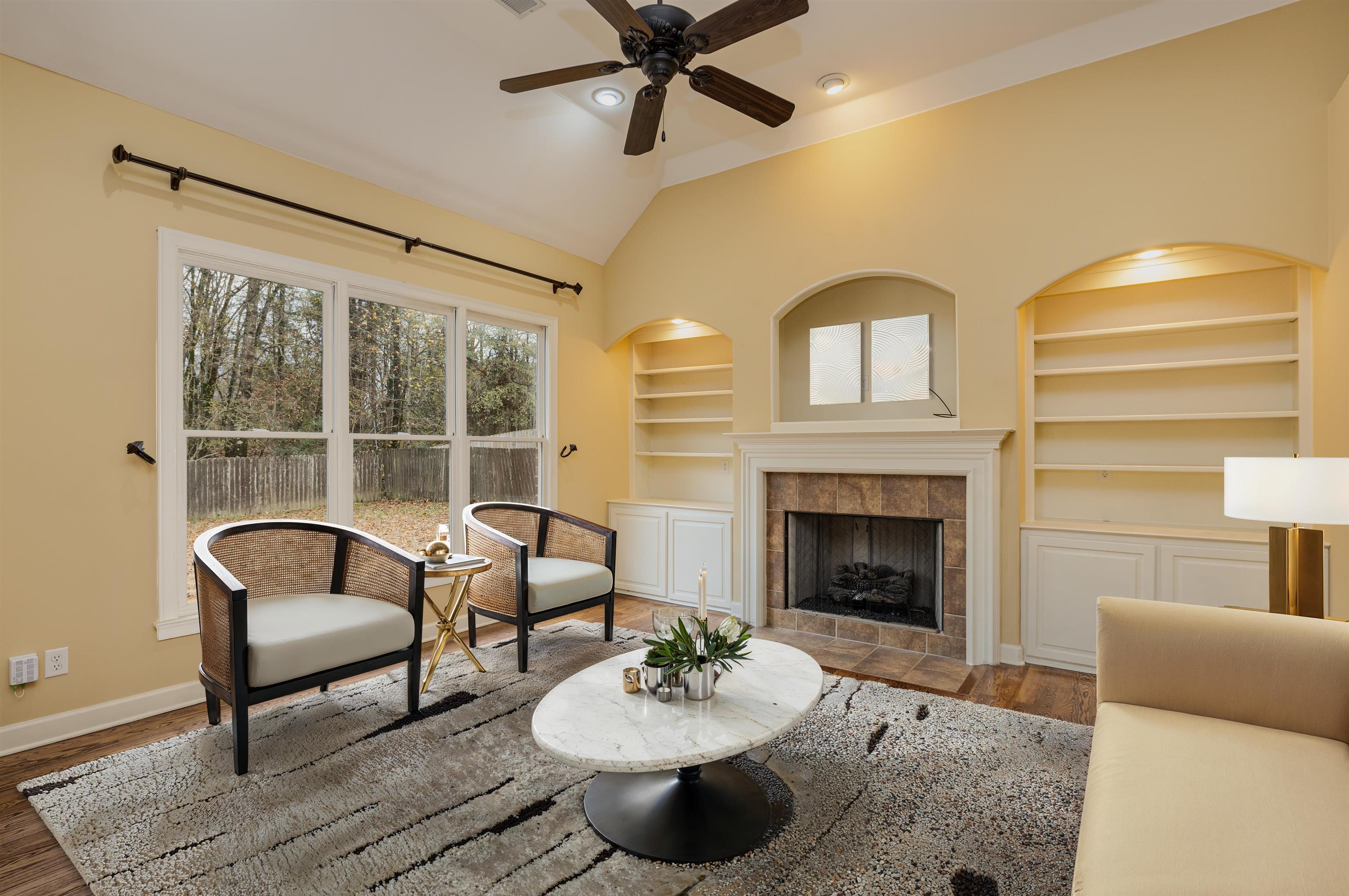 5380 Scarlet Ridge Drive Arlington, TN 38002 - Photo 12 of 30 Hearth room featuring a tile fireplace, vaulted ceiling, built in features, wood finished floors, and ceiling fan