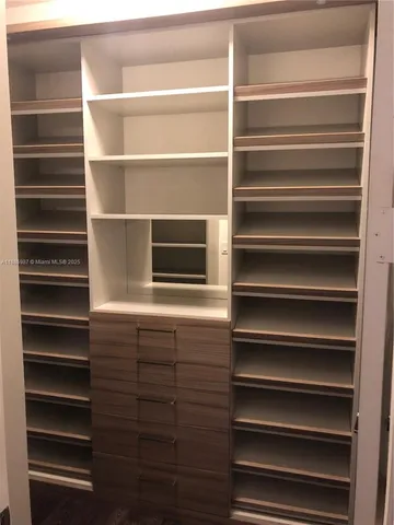 a view of walk in closet with empty racks