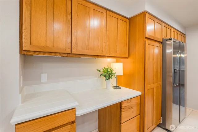 a kitchen with a sink a refrigerator and cabinets
