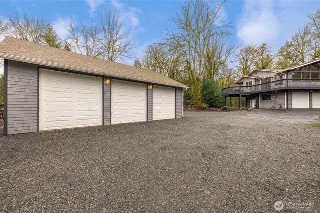 a backyard of a house with large trees and brick wall