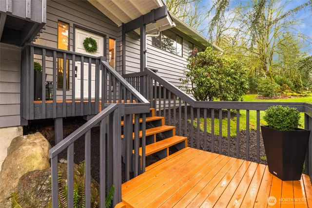 a view of balcony with wooden floor and large trees