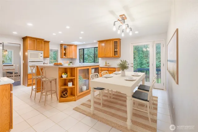 a view of a dining room with furniture a chandelier and a large window