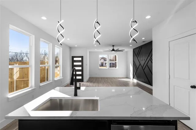 a view of a kitchen island a chandelier and wooden floor