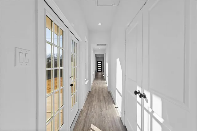 a view of a hallway with wooden floor and staircase