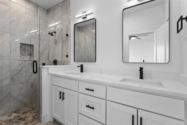 a bathroom with a sink mirror and shower