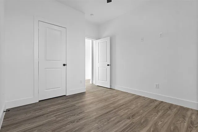 a view of an empty room with wooden floor