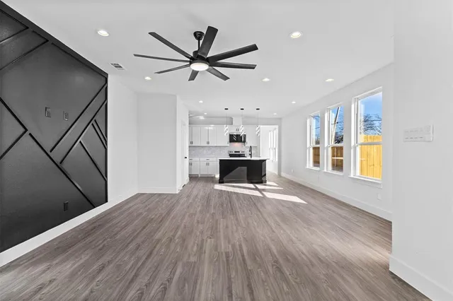 a view of empty room with wooden floor and window