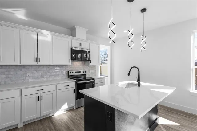 a kitchen with appliances cabinets a sink and a counter top space