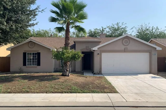 a front view of a house with a yard garage and outdoor seating