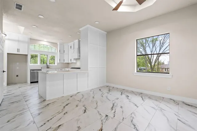 a kitchen with a sink window and cabinets