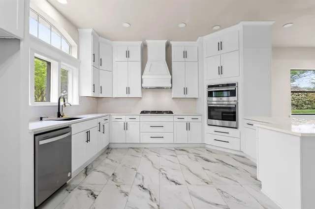 a kitchen with stainless steel appliances cabinets and a window