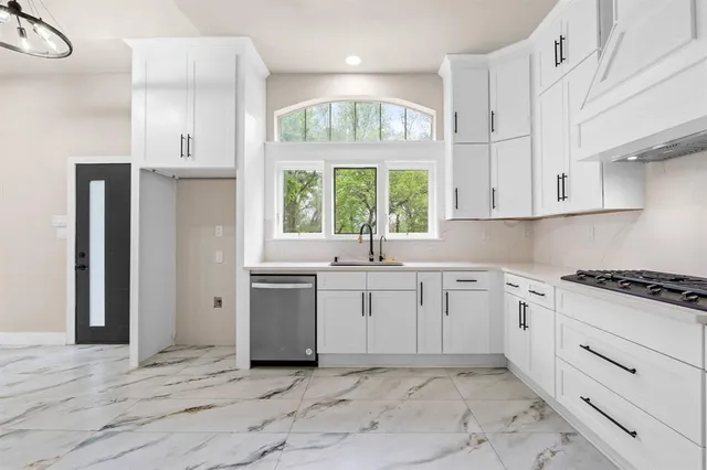 a kitchen with a stove a sink and a window