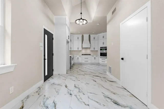 a view of a kitchen with a sink and dishwasher a refrigerator with wooden floor
