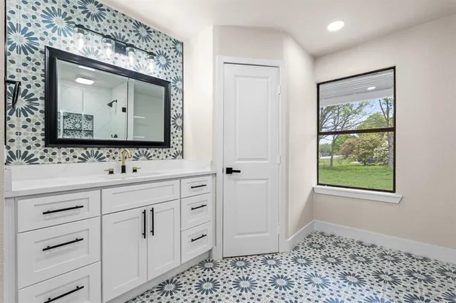 a bathroom with a sink a mirror and a window