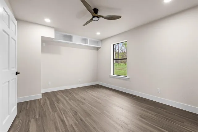 wooden floor in an empty room with a ceiling fan