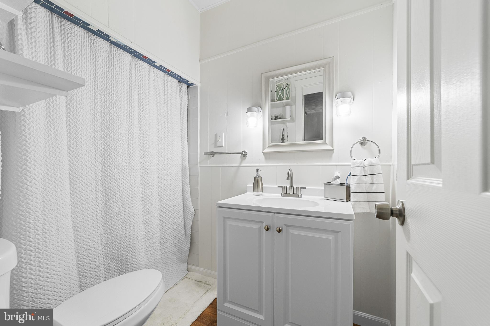 320 West Maple Avenue Merchantville, NJ 08109 - Photo 49 of 67 a bathroom with a toilet a sink a mirror a shower curtain