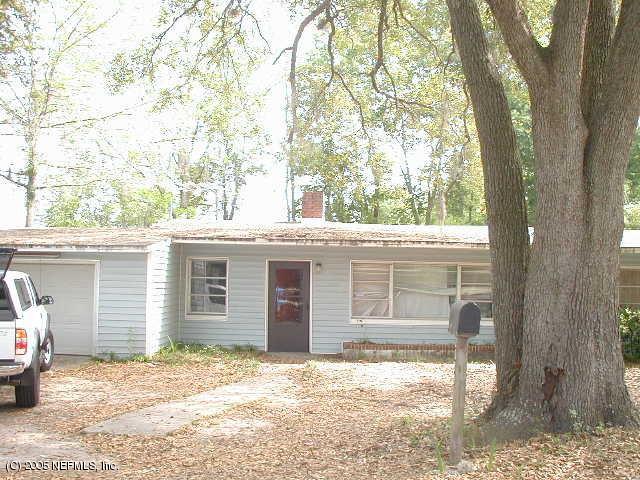a backyard of a house with large trees and barbeque oven