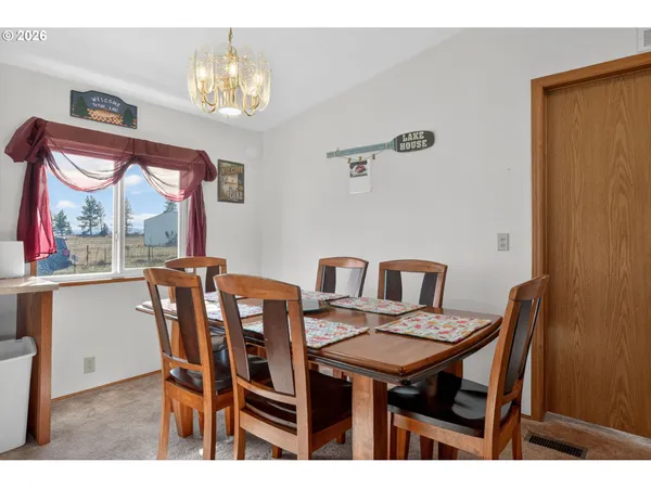 a view of a dining room with furniture a chandelier and wooden floor