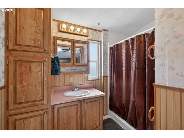 a bathroom with a sink a mirror and a shower