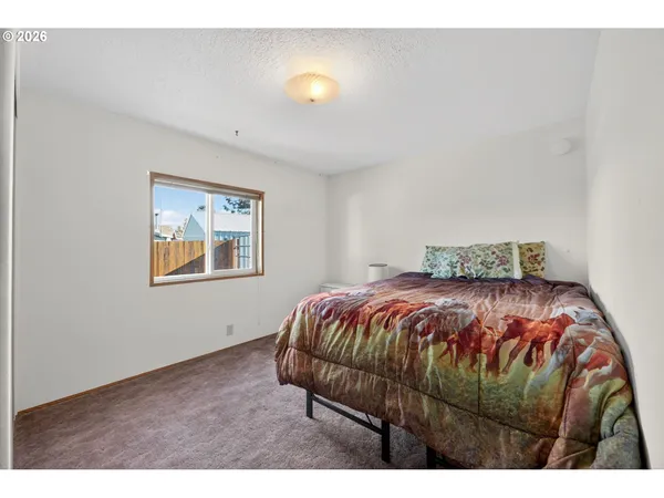 a bedroom with a bed and painting on the wall