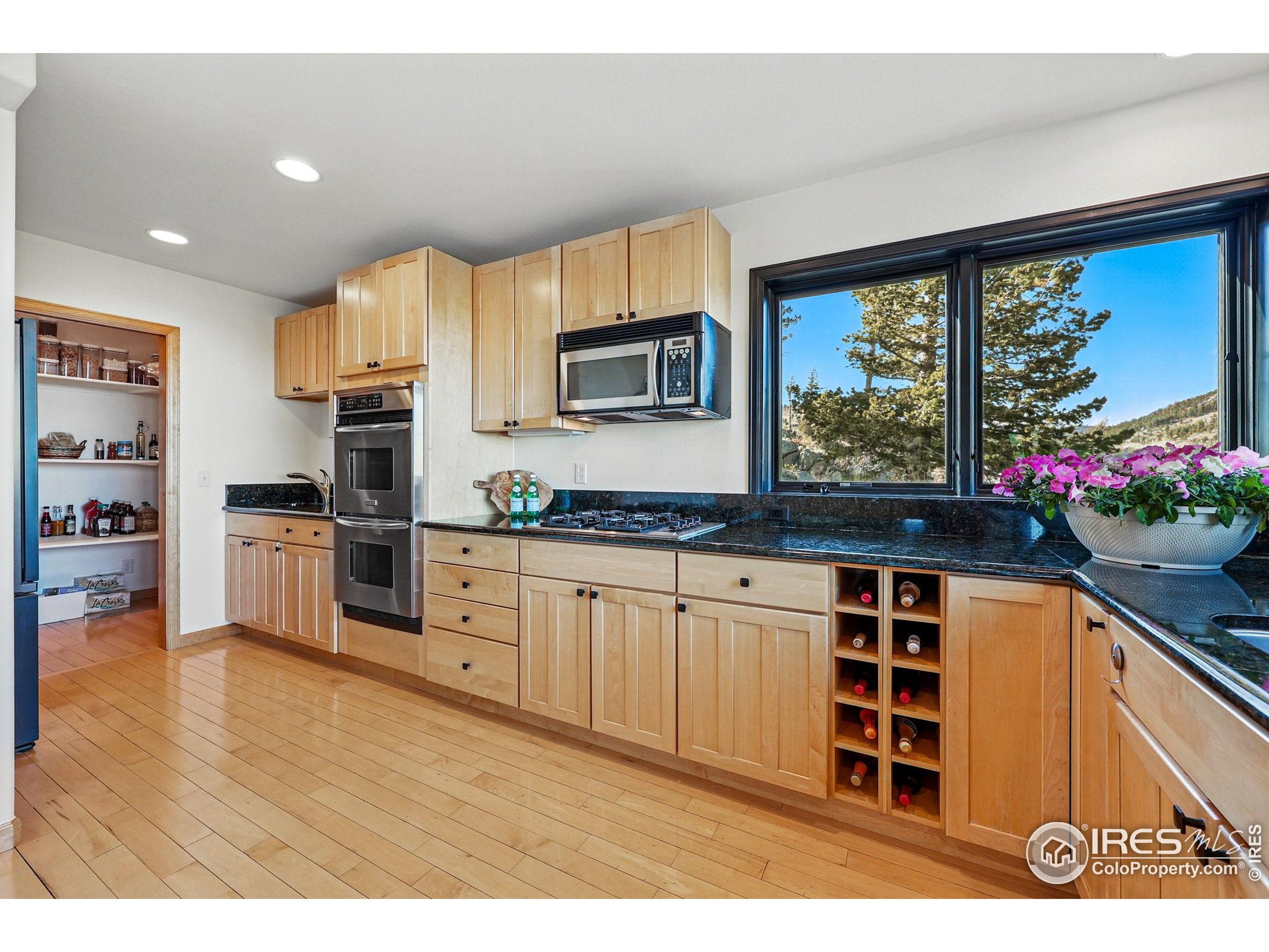 98 Rim Road Boulder, CO 80302 - Photo 12 of 43 a kitchen with granite countertop a stove a sink and a microwave