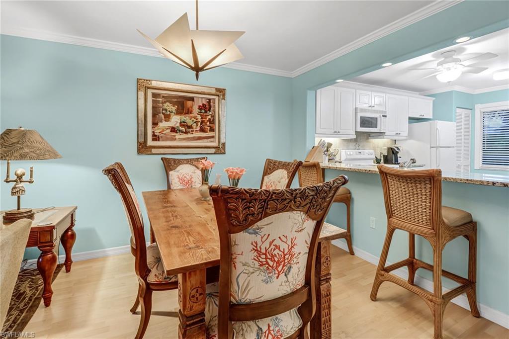 3041 Sandpiper Bay Circle, Unit H201 Naples, FL 34112 - Photo 11 of 25 Dining space featuring crown molding, light wood-style floors, and ceiling fan