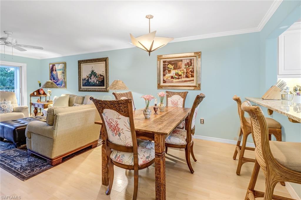 3041 Sandpiper Bay Circle, Unit H201 Naples, FL 34112 - Photo 12 of 25 Dining area with crown molding, light wood finished floors, and a ceiling fan