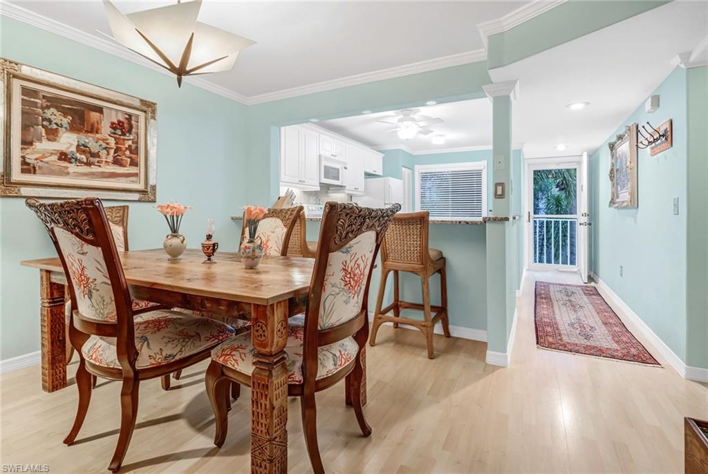 3041 Sandpiper Bay Circle, Unit H201 Naples, FL 34112 - Photo 13 of 25 Dining room featuring light wood-type flooring, crown molding, and ceiling fan